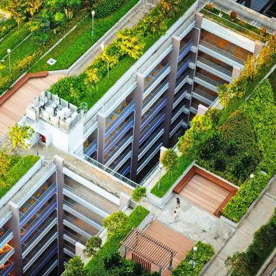 An aerial view of a building with green and living spaces on the roof.